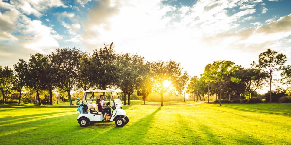 Father and daughter drive on scenic golf course in West Palm Beach Florida