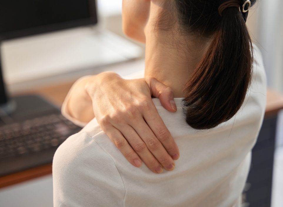 Woman holding her shoulder in discomfort