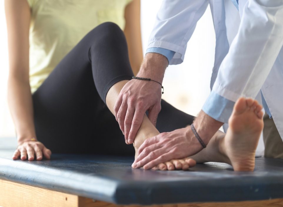 Doctor evaluating a woman's sprained ankle