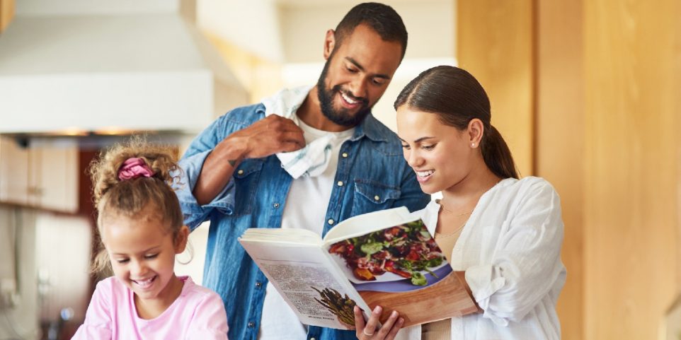 Shot of a couple and their daughter cooking together in the kitchen